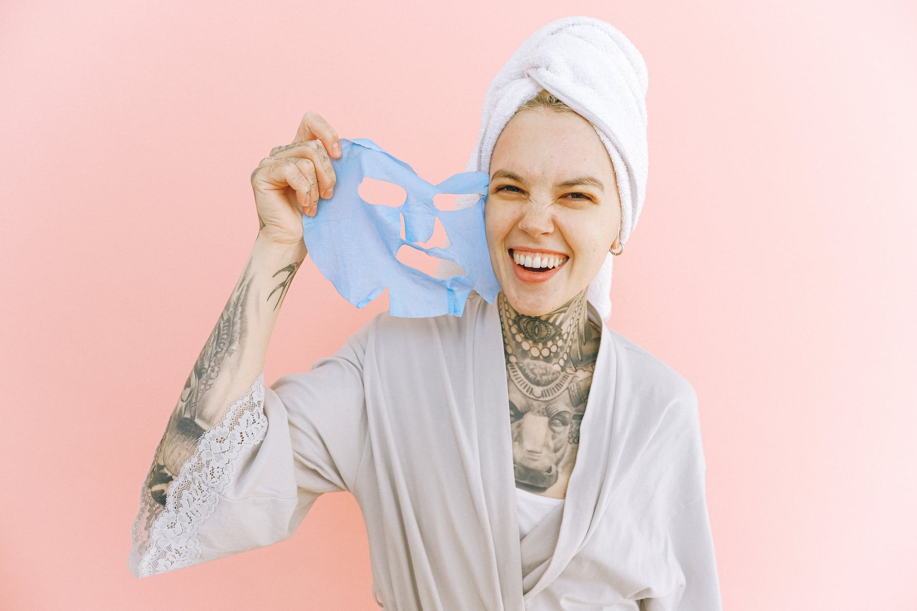 happy woman removing face mask after taking bath