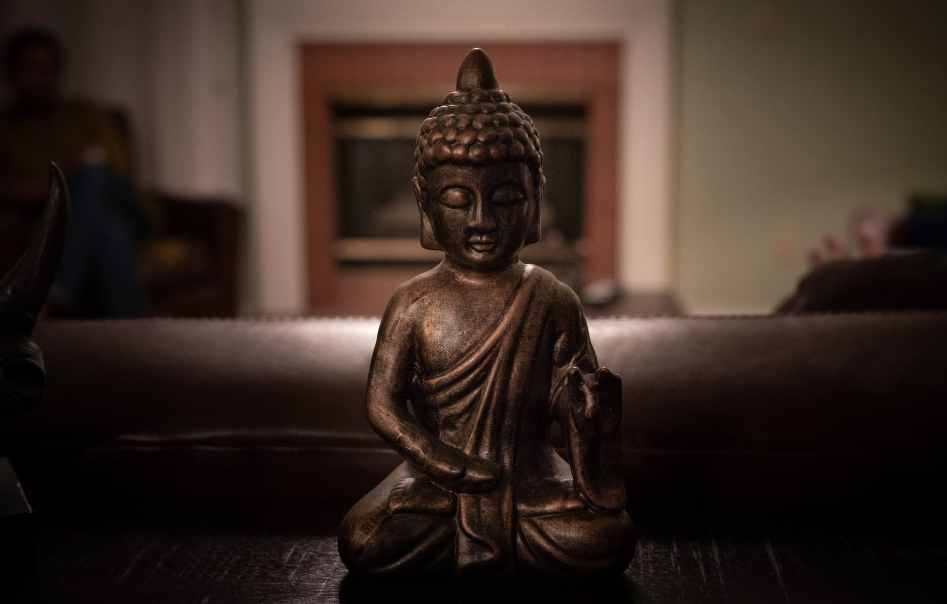 brass buddha figurine on black surface